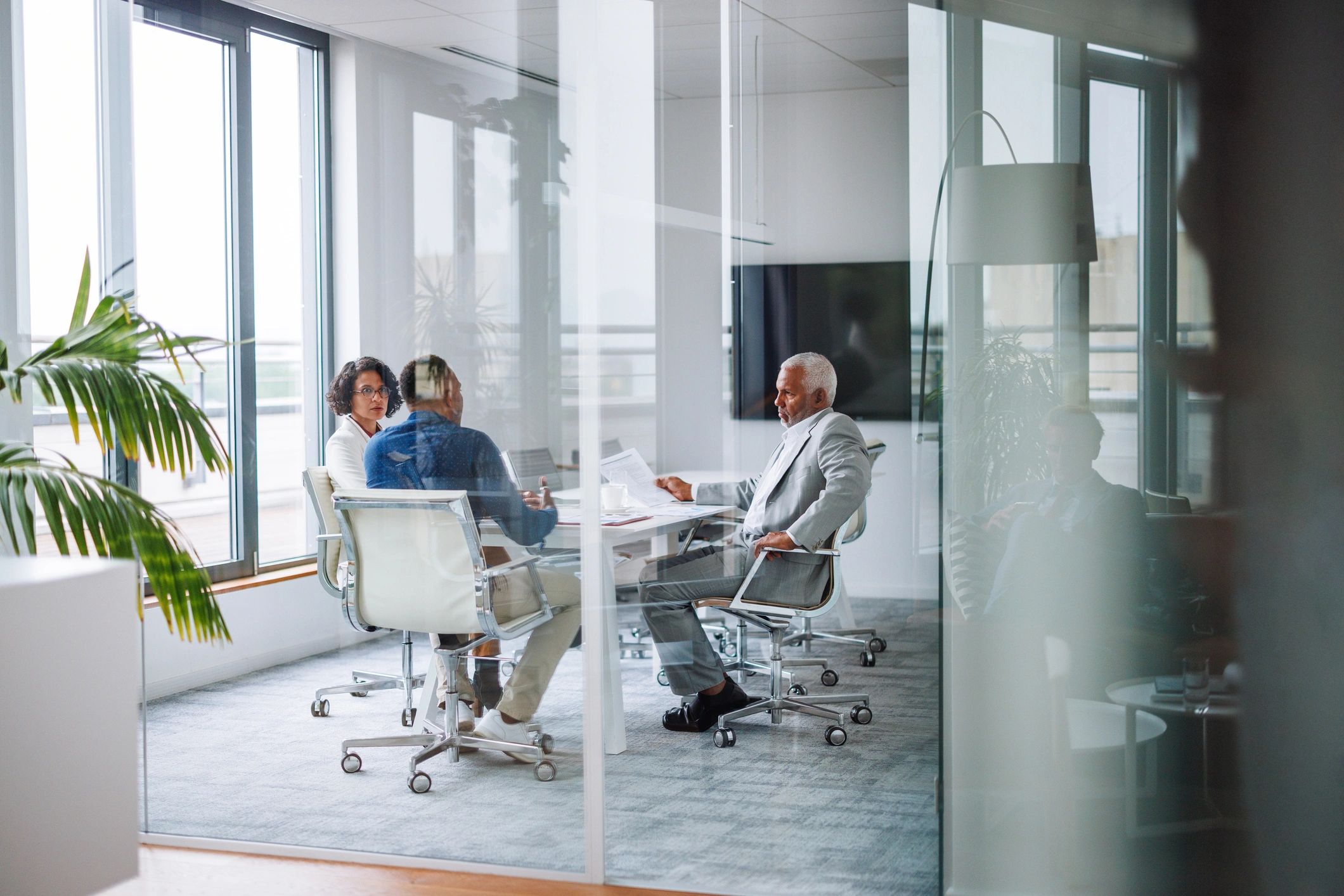 Professionals meeting in a glass-walled conference room